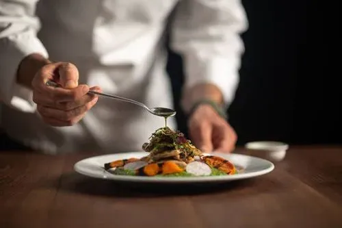 Chef terminando un plato colombiano servido en Noches De Colombia de South Hackensack